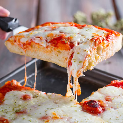 a pizza being lifted from a pan with cheese